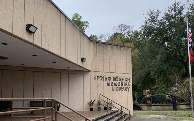 The front steps and sign of Spring Branch Memorial Library, with the playground next door